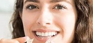 mujer colocándose ortodoncia invisible